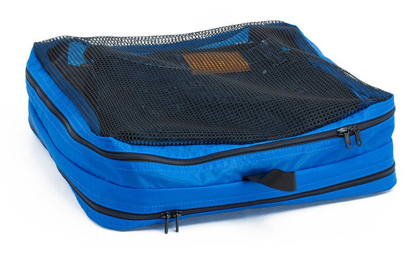 A filled and zipped closed Island (blue) Aether Large Laundry Aeronaut 45 Packing Cube mesh side up.